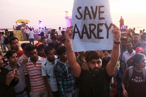An activist holds a placard during a protest against cutting down of trees for a proposed metro car shed project at Aarey Colony in Mumbai Sunday Oct. 6 2019. | (Photo | PTI)