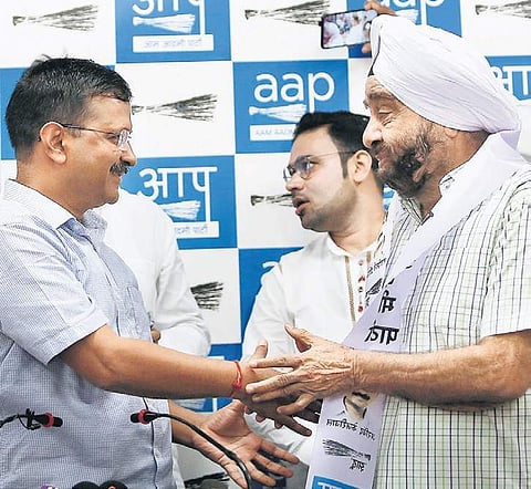 Former Congress MLA Parlad Singh Sawhney shakes hands with AAP national convenor Arvind Kejriwal during his induction into the party on Sunday. (Photo | Arun Kumar, EPS)