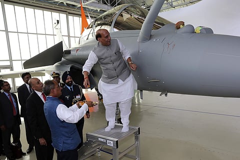 Union Defence Minister Rajnath Singh has a ritual gesture onto a Rafale jet fighter during the handover cermony at the Dassault Aviation plant in France's Merignac on Tuesday, Oct. 8, 2019. France has delivered to India its first Rafale fighter jet from a