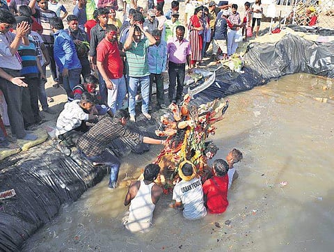 Devotees immerse an idol of Goddess Durga in an artificial pond. (Photo | EPS/Arun Kumar)