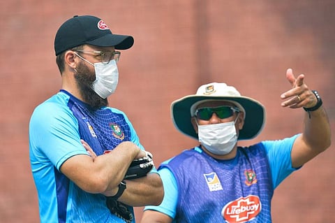 Bangladesh cricket team head coach Russell Domingo (R) and bowling coach Daniel Vettori wearing face masks watch the team during a practice session at Arun Jaitley Cricket Stadium in New Delhi. (Photo | AFP)