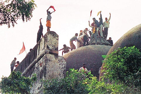 Hindu fundamentalists shout and wave saffron banners as they climb stone walls and demolish the domes of the 16th century Babri Mosque in Ayodhya on December 6, 1992 (File Photo)