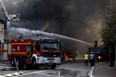 Firefighters deploy after a factory hit by a rocket caught fire in Sderot, southern Israel. (Photo | AP)