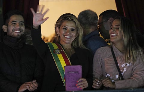 Bolivia's second Senate Vice President and opposition politician Jeanine Anez, center, wearing the Presidential sash, addresses the crowd from the balcony of the Quemado palace after she declared herself interim president of the country, in La Paz. (Photo