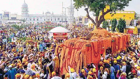 Sikh devotees participate in a religious procession to mark Guru Nanak’s 550th birth anniversary at Gurdwara Nankana Sahib in Pakistan on Tuesday | PTI