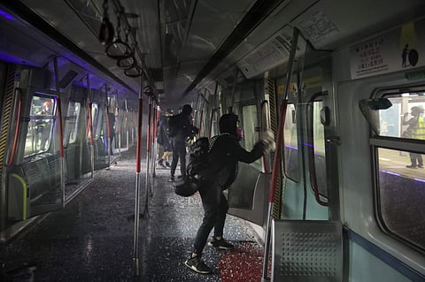 Pro-democracy protesters vandalize a train parked inside the Chinese University MTR station in Hong Kong on Wednesday. Protesters in Hong Kong battled police on multiple fronts on Tuesday, from major disruptions during the morning rush hour to a late-nigh
