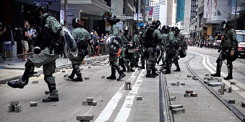 Police kick away bricks placed by demonstrators to barricade a road during a protest in the financial district in Hong Kong, Thursday, Nov. 14, 2019. (Photo | AP)