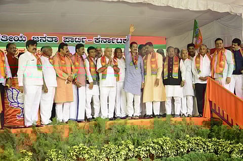 BJP national secretary P Muralidhar Rao gives safron flag to the 16 disqualified Karnataka MLAs and officially induct them to BJP. | (Photo | Shriram BN/EPS)