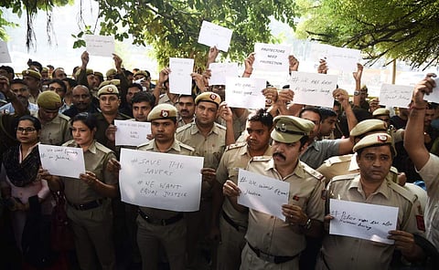 Delhi Police officials holding posters during a protest demonstration against the recent attack by lawyers at the Police headquarters in New Delhi. (Photo | Parveen Negi, EPS)