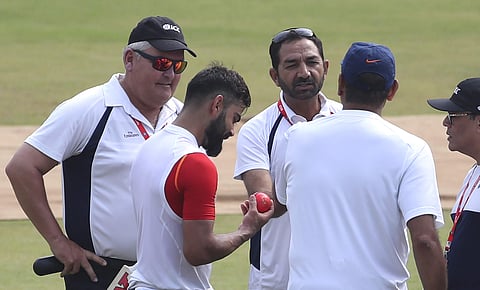 India's captain Virat Kohli, second left, checks out the new pink ball as he interacts with umpires after batting in the nets during a training session ahead of their first cricket test match against Bangladesh in Indore, India, Wednesday, Nov. 13, 2019.