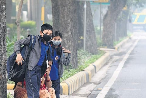 Students cover their faces with masks to protect themselves from morning air pollution, in Delhi . (Photo | EPS, Parveen Negi)