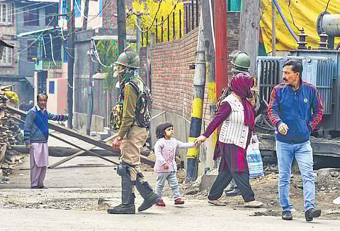 A security person patrols a street in downtown Srinagar on Friday. Though the public transport remained off the roads, private vehicles were seen plying despite security restrictions in the Kashmir Valley (Photo| PTI)