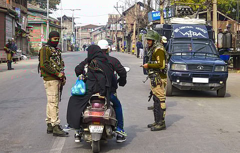 Security personnel ask a scooterist to divert his route during restrictions in parts of Downtown in Srinagar (Photo| PTI)