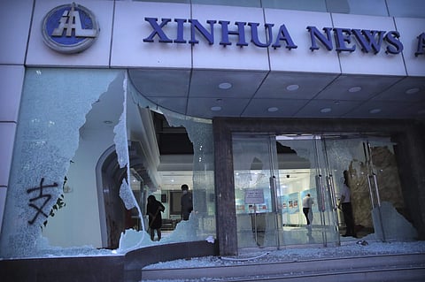 People stand inside the lobby of China's Xinhua News Agency damaged by protesters in Hong Kong, Saturday, Nov. 2, 2019. (Photo | AP