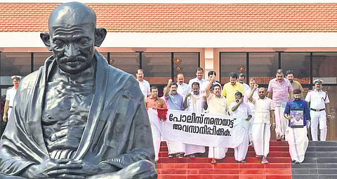 Opposition MLAs coming out of the assembly holding a banner that reads ‘End police excesses’ in Thiruvananthapuram on Wednesday | B P Deepu