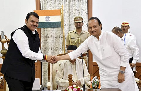 Newly sworn in Chief Minister of Maharashtra Devendra Fadnavis shakes hands with his Deputy Chief Minister Ajit Pawar in Mumbai Saturday Nov. 23 2019. (Photo | PTI)