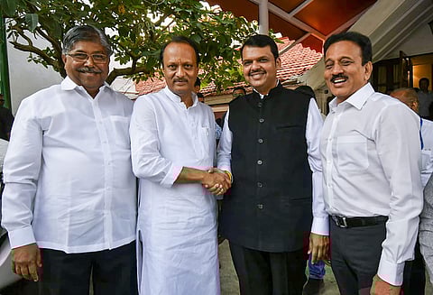 Newly sworn in Chief Minister of Maharashtra Devendra Fadnavis shakes hands with his Deputy Chief Minister Ajit Pawar in Mumbai Saturday Nov. 23 2019. (Photo | PTI)