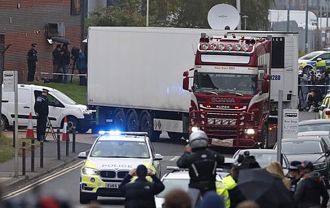 Police escort the truck, that was found to contain almost 39 dead bodies. (Photo | AP)