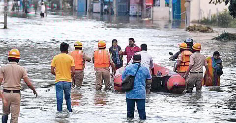 Emergency personnel evacuate residents after a breach in Hulimavu lake flooded several areas on Sunday