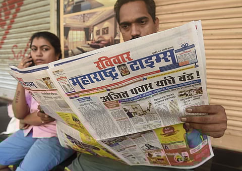 A local reads newspaper fronted with headlines on Maharashtra government formation in Mumbai Sunday Nov. 24 2019. (Photo | PTI)