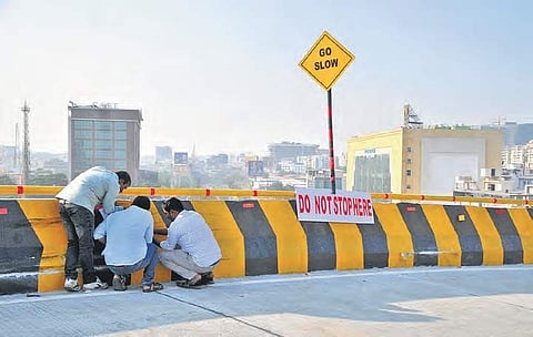 Officials examining the spot from where a speeding car climbed the Biodiveristy flyover's railing and fell on the road below on Saturday in Hyderabad.