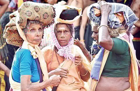 Old Malikappurams trying to find a place to tie a bell that they brought from their native place on the wall of the temple after darshan at Sabarimala on Sunday | Shaji Vettipuram