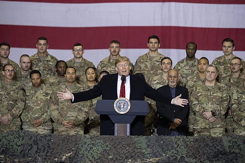 President Donald Trump, center, with Afghan President Ashraf Ghani and Joint Chiefs Chairman Gen. Mark Milley, behind him at right, while addressing members of the military during a surprise Thanksgiving Day visit, Thursday, Nov. 28, 2019, at Bagram Air F