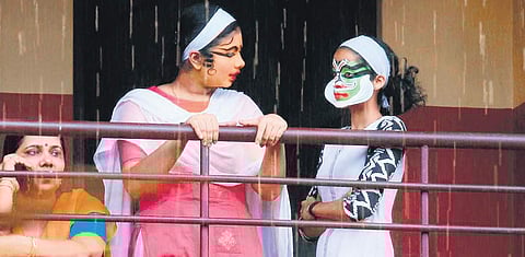 Kathakali participants sharing a light moment before their performance (R) A kathakali artist quenching her thirst