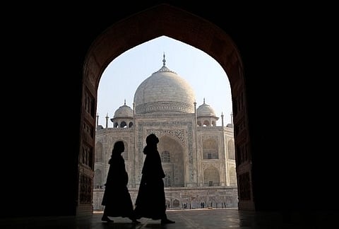 Indian tourists walk past an archway at the historic Taj Mahal in Agra. (Photo | AFP)