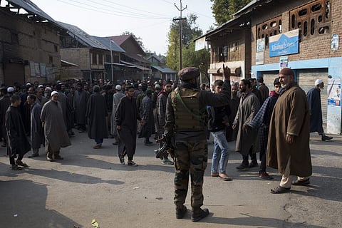 Soldier talks to Kashmiri villages who where ordered to assemble at one place for questioning near the spot where Indian laborers were killed by gunmen in Katrasoo village. (Photo | AP)
