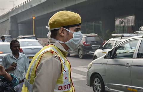 A Civil Defence volunteer wearing a pollution mask on duty to help implement the odd-even scheme in New Delhi Monday Nov. 4 2019. | (Photo | PTI)