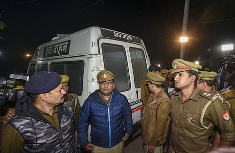 Policemen stand near an ambulance carrying the mortal remains of the rape victim who succumbed to severe burns in Delhi hospital arrived at her native village in Unnao district Saturday Dec.7 2019. (File | PTI)