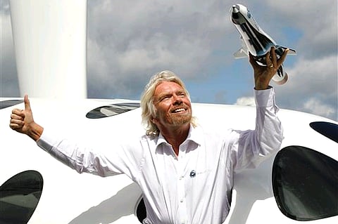 Sir Richard Branson poses for the photographers in the window of a replica of the Virgin Galactic. (File photo)