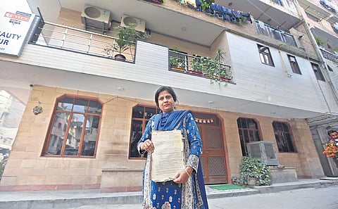 Nafisa Ali, holds a document labelling her as a tenant in the colony