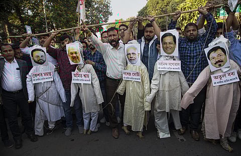 All Assam Student's Union activists hang the effigies of Indian Prime Minister Narendra Modi, middle and Home Minister Amit Shah, second from left and Assam Chief Minister Sarbananda Sonowal, second from right, during a protest against the Citizenship Ame
