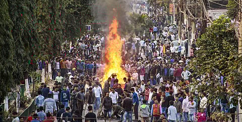 Protestors burn hoardings and other materials during their march against the Citizenship Amendment Bill in Guwahati. (Photo | PTI)