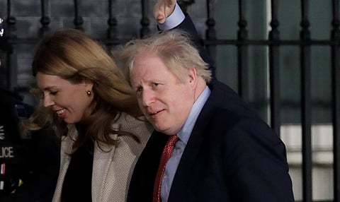 Britain's Prime Minister Boris Johnson and his partner Carrie Symonds arrive back in Downing Street in London, Friday, Dec. 13, 2019. (Photo | AP)