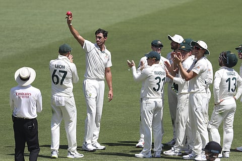 Australia's Mitchell Starc holds the ball high after taking five wickets against New Zealand during play in their cricket test in Perth.