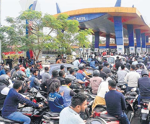 People queue up at a petrol pump during relaxed hours of curfew in Jorhat district of Assam on Friday. (Photo | PTI)
