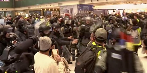 In this image made from video, police and protester scuffle at a shopping mall in Sha Tin district in Hong Kong, with shoppers watch from balconies above. (Photo | AP)