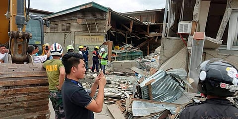 Residents and rescuers check damaged structures following an earthquake that struck Padada, Davao del Sur province, southern Philippines on Sunday. (Photo | AP)