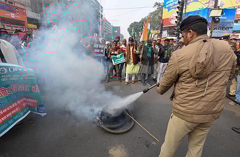 A Police personnel attempts to douse a burning tyre during a demonstration against NRC and Citizenship Amendment Act CAA in Patna Saturday Dec. 21 2019. (Photo | PTI)