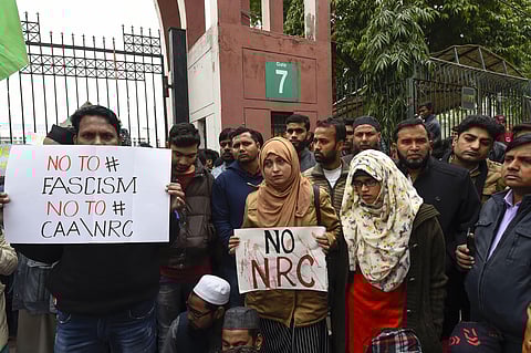 Students along with general public hold placards during a protest against the Citizenship Amendment Act (CAA) outside Jamia Millia Islamia University. (Photo | PTI)