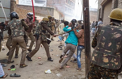 Police personnel baton charge on a commuter who rode too close to a barricade set up on a street in view of anti-CAA protests in Jabalpur (File photo| PTI)