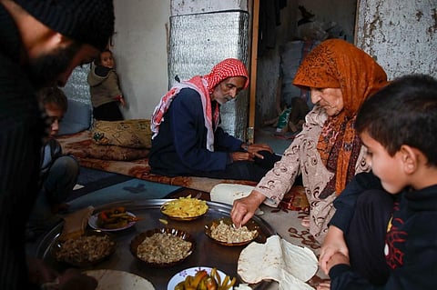 Umm Khaled and her family share a meal in a camp in a town called Haarem in the northwestern province of Idlib on November 29, 2019. (Photo | AFP)