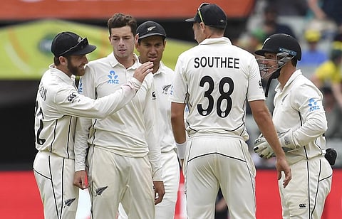 New Zealand bowler Mitchell Santner (2nd L) is congratulated by teammate Kane Williamson (L) after dismissing Australia's Joe Burns on the third day of the second cricket Test match at the MCG in Melbourne. (Photo | AFP)