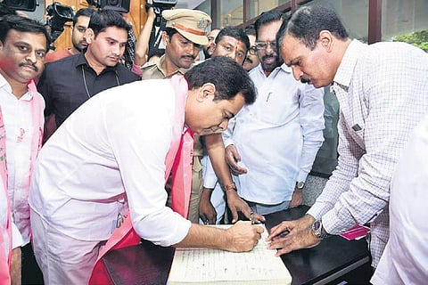 TRS leader KT Rama Rao signing a register at party office in Hyderabad on Friday after attending the State committee meeting which met to discuss strategy for the upcoming municipal polls