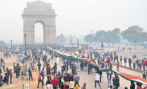 Demonstrators, protesting the alleged police action on CAA agitators, hold the tricolour in front of the India Gate, in New Delhi on Monday. (Photo | Parveen Negi, EPS)
