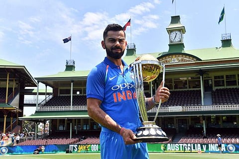 Virat Kohli poses with the ICC Cricket World Cup trophy. (Photo | AFP)