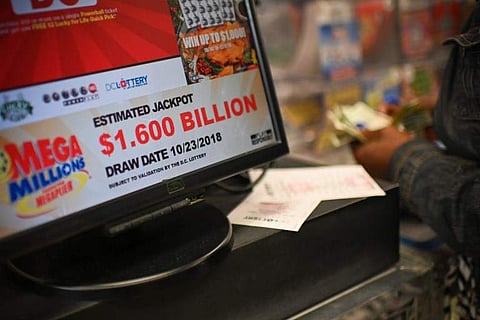 A woman buys Mega Millions tickets hours before the draw of the $1.6 billion jackpot, at a liquor store in Downtown Washington DC, on October 23, 2018. The advertised $1.6 billion Mega Millions prize — the world's largest ever lottery jackpot — and $620 m